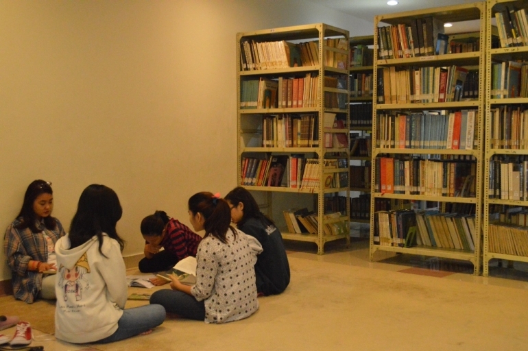 Ilustrasi membaca buku di perpustakaan kampus (Sumber: ukwms.ac.id)