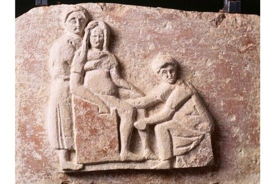 Sebuah relief abad kedua Masehi di makam bidan Romawi Scribonia Attica menggambarkannya di tempat kerja. /Foto : Getty Images