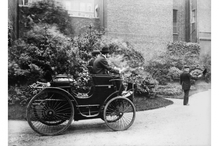 Pabrikan mobil Charles Stewart Rolls mengendarai mobil pertamanya di akhir abad ke-19, dengan seorang pria berjalan di depan dengan bendera merah sesuai hukum yang berlaku saat itu. /Foto : Topical Press Agency