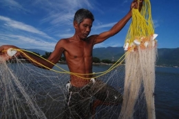 Seorang nelayan memasang pukat darat untuk menangkap udang di Teluk Palu, Sulawesi Tengah | Sumber: fiqmansunandar.wordpress.com