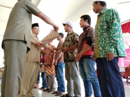 Syamsul Suli (kiri) menyerahkan bantuan benih kepada petani Bantaeng (29/04/19).