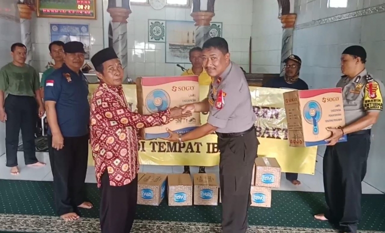 Panit Binmas Ipda Warto menyerahkan bantuan untuk DKM Masjid Baitussalam