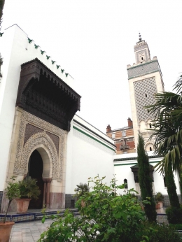 Menara beserta pintu yang menghubungkan taman dengan halaman masjid dilihat dari semak-semak di antara bunga-bunga (foto : Derby Asmaningrum)
