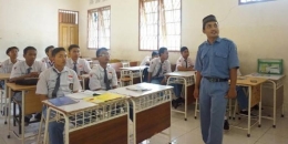 Ilustrasi: Moch Hamzah Rifwan (33), guru tidak tetap di SMKN 2 Surabaya, Jawa Timur, mengajar mata pelajaran Pendidikan Agama Islam, Selasa (10/1). Mulai tahun ini, gajinya sebagai guru tidak tetap dibayar menggunakan uang sumbangan pembinaan pendidikan setelah Pemerintah Kota Surabaya tidak bisa mencairkan dana bantuan operasional daerah karena pengelolaan SMA/SMK beralih dari pemerintah kabupaten/kota ke pemerintah provinsi.(Kompas/Iqbal Basyari)