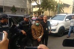 HS (25), pria yang mengancam memengal Presiden Joko Widodo digiring ke Mapolda Metro Jaya, Minggu (12/5/2019). (KOMPAS.com/NIBRAS NADA NAILUFAR)