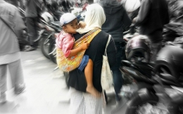 Seorang peminta-minta yang menggendong anak kecil sedang meminta sumbangan di tengah keramaian Kota Yogyakarta (dok. pri).