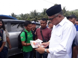Gambar 3, Kamarudin menunjukkan karya buku TTSnya kepada Plt Gubernur Aceh (Doc. FMT)