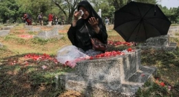 Seorang ibu berziarah di makam korban tragedi mei 98.foto : tempo/Muhammad hidayat