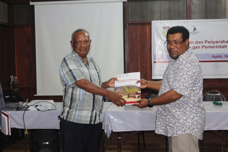 Guru Felix menerima buku kegiatan LANDASAN Papua dari Septer Manufandu. Dokpri.