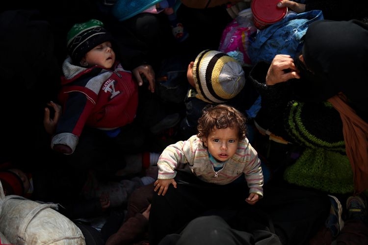 Anak-anak bersama warga sipil lainnya melarikan diri dari sebuah kelompok radikal di Suriah, duduk di belakang sebuah truk dekat Baghuz, Suriah timur, Senin (11/2/2019) waktu setempat. Jutaan anak menjadi korban dalam perang saudara di Suriah yang berlangsung sejak 2011, selain dibunuh, disiksa, dan diculik, mereka juga menderita gizi buruk dan kerap menjadi tameng hidup di medan perang.(AFP PHOTO/DELIL SOULEIMAN)
