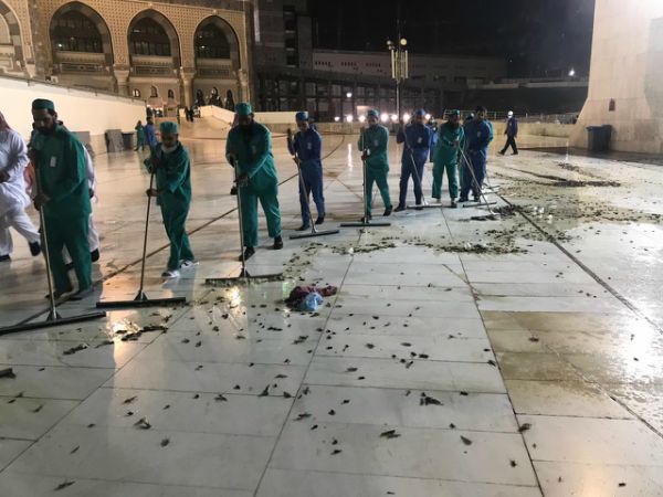 Petugas di Masjidil Haram tengah memberishkan lantai, bangkai jangkrik terlihat bertebaran. Foto | Ouakas.Info