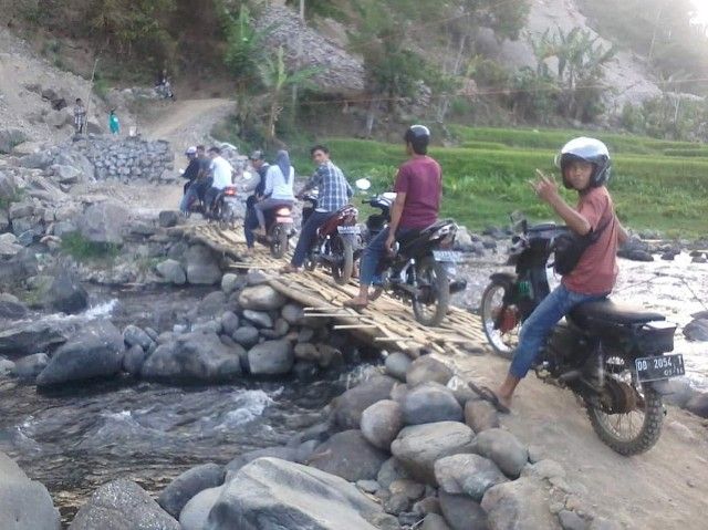 Muhlis Majid saat Mudik melewati jembatan di kampungnya dengan kendaraan roda dua. (dokpri)