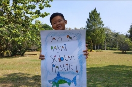 Alvin Leonard (7) getol berkampanye melawan sedotan plastik dengan media poster yang ia gambar sendiri.(KOMPAS.com/Vitorio Mantalean) 