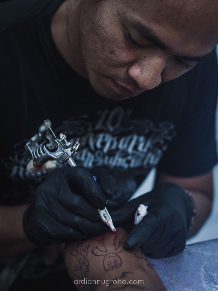 Hudha dengan hati-hati mengubah sketsa yang ia buat sebelumnya menjadi tato permanen. (Dokumentasi pribadi)