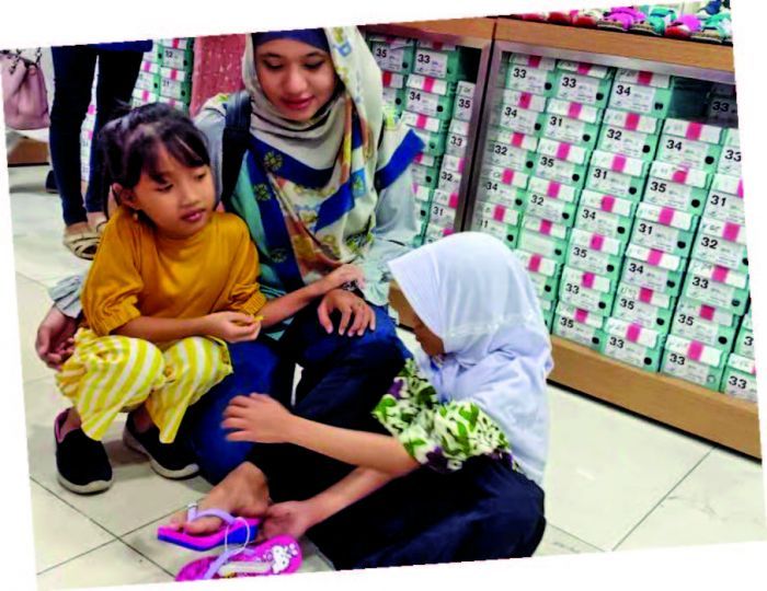 Salah satu anak yang sedang mencoba sandal baru (mediaindonesia.com)