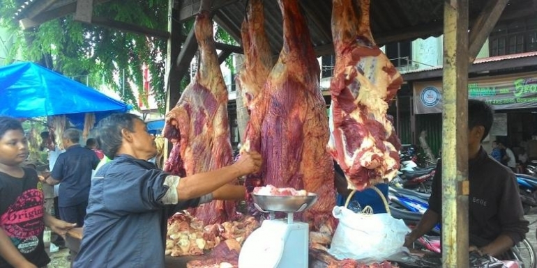 Seorang pedagang di pasar tradisional di Banda Aceh sedang berjualan daging sapi. Setiap hari Makmeugang warga berbondong-bondong membeli daging sapi untuk dimakan bersama keluarga. Harga daging sapi dijula Rp130-150 ribu perkilogramnya. (Kompas.com/KONTRIBUTOR BANDA ACEH, DASPRIANI Y ZAMZAMI)