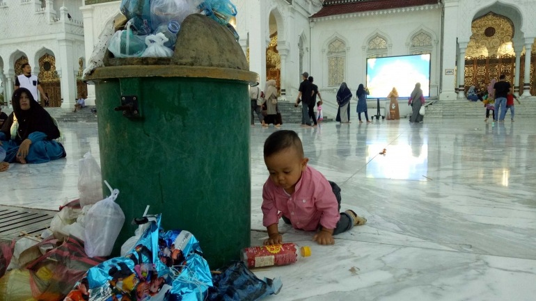 Bayi pengunjung Masjid Raya Baiturrahman terlihat mendekati sampah di halaman depan masjid, Minggu, 9/6/2019 | dokumentasi pribadi 