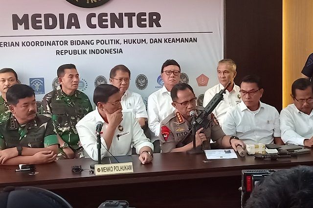 Kapolri Jenderal Tito Karnavian saat menunjukan senjata api berjenis M4 di kantor Kemenkopolhukam, Jalan Medan Merdeka Barat, Jakarta Pusat, Rabu (22/5). (Muhammad Ridwan/ JawaPos.com)
