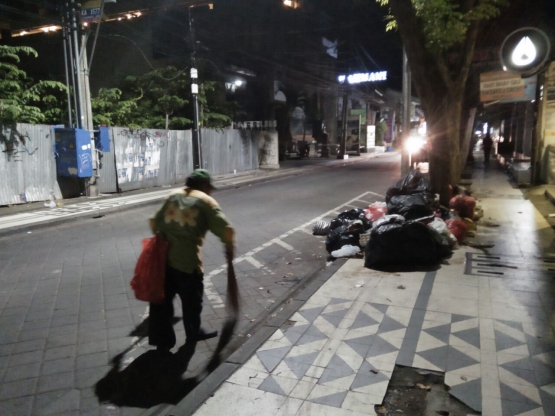 Petugas kebersihan sedang menyapu jalan pada suatu subuh di sekitar jalan menuju Pantai Kuta-Bali (03/2018), (dok.pri)