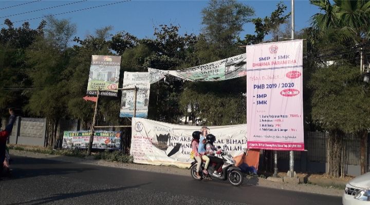 Pengendara motor melintas di depan banner penerimaan murid baru sebuah sekolah swasta di Cikarang(dokpri)