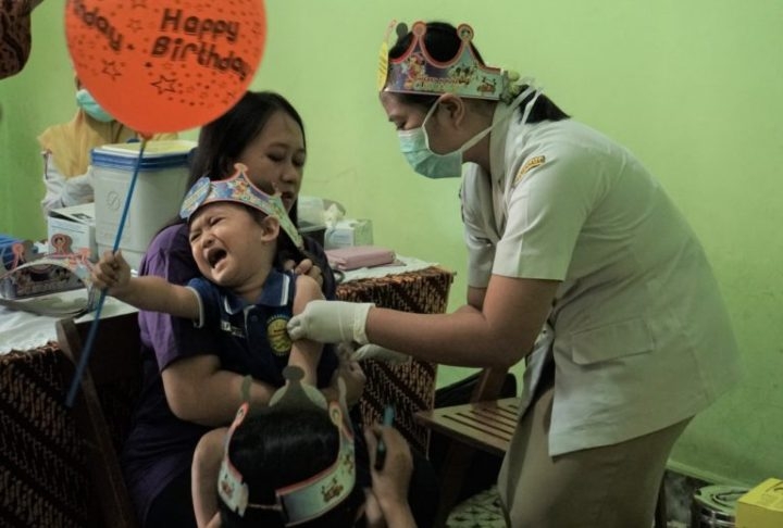 Seorang anak menangis saat diimunisasi measles-rubella (MR) di Solo, Jawa Tengah, Selasa, (1/8/2017). Pemberian imunisasi ini akan menyasar seluruh anak usia 9 bulan sampai 15 tahun di Solo. | KOMPAS/ERWIN EDHI PRASETYA