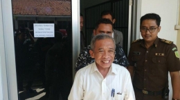 Mantan pelawak era 1990-an, Nurul Qomar, dibawa petugas Kejaksaan Negeri (Kejari) Brebes untuk pemeriksaan usai dilakukan pelimpahan tahap II dari Polres Brebes, Rabu (26/6/2019). | Tribun Jateng/ M Zaenal Arifi