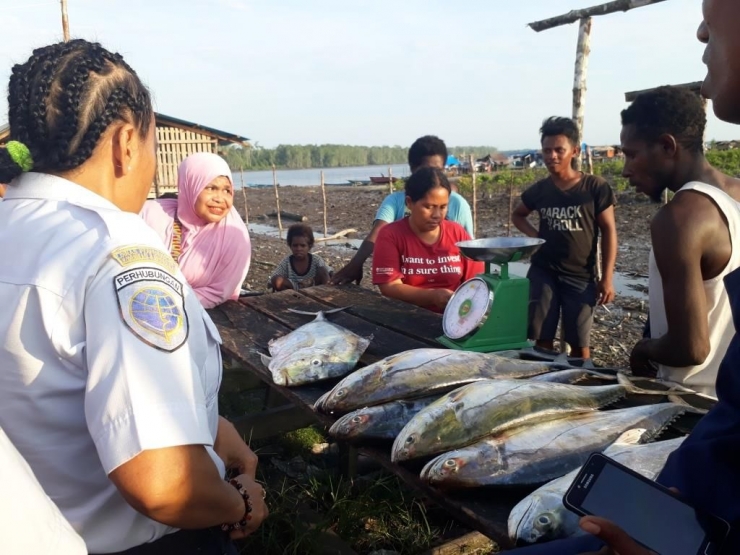 Warga Timika Sedang Bertransaksi Membeli Ikan di Pelabuhan Pomako, Mimika, Papua. Dok:Pribadi