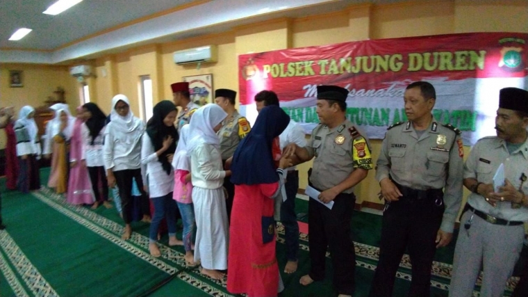 Kapolsek Tanjung Duren sedang memberikan santunan bagi anak yatim piatu