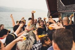 Peserta boat party di event yang digelar Volcano Floating Party menunjukkan minumannya di atas kapal di Danau Toba. (Doc. Volcano Floating Party)