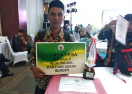 Munirwan saat menerima penghargaan Juara 2 Inovasi Desa Tingkat Nasional.   (Sumber Foto ; www.national.tempo.co) 