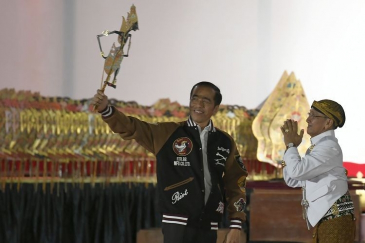 Jokowi memainkan wayang Kresna yang diterimanya dari Ki Manteb Soedharsosno (kompas.com).