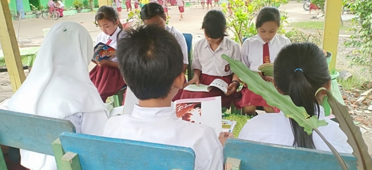 Anak-anak membaca buku di lokasi taman. Foto oleh Dedy Hutajulu
