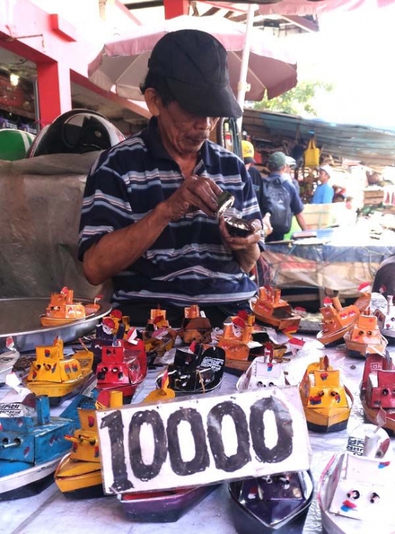 Pedagang Mainan 'Kapal Klotok' Sedang Memeriksa Dagangannya (Sumber: Koleksi Pribadi)