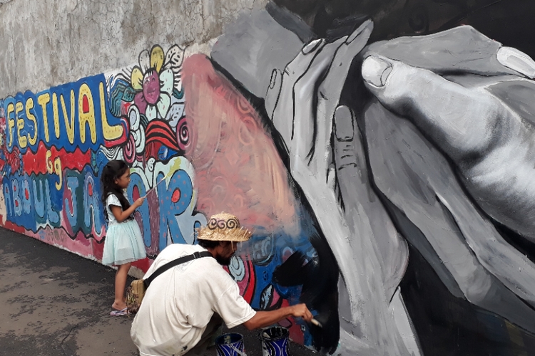 ilustrasi. Sam Herry tampak hendak menggambar mural bertema Mural Islami di Gang Abdul Jabar, Kelurahan Jagakarsa, Jakarta Selatan, Rabu (23/5/2018) sore. Seorang anak perempuan ikut menggambar di dinding tersebut. (KOMPAS.com/NURSITA SARI)