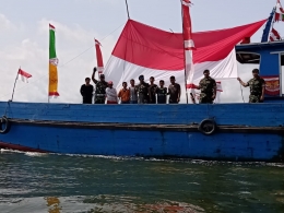 Pawai bendera menggunakan kapal kayu | Dokumen Yonif Raider 600 Modang