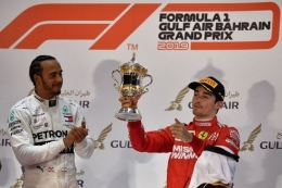 Pebalap Ferrari, Charles Leclerc (kanan), mengangkat trofi setelah finis urutan ketiga pada balapan GP Bahrain, di Sirkuit Sakhir, Bahrain, Minggu (31/3/2019). (AFP/ANDREJ ISAKOVIC)