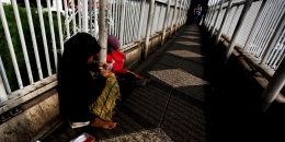 Pengemis mengais iba dari pejalan kaki yang melintasi jembatan penyebrangan orang di Semanggi, Jakarta Pusat, Jumat (7/3/2014). Pemerintah provinsi DKI perlu menata ulang jembatan penyebrangan orang agar tidak hanya nyaman bagi pejalan kaki, tetapi juga aman dari tindak kejahatan. Kompas/Lucky Pransiska