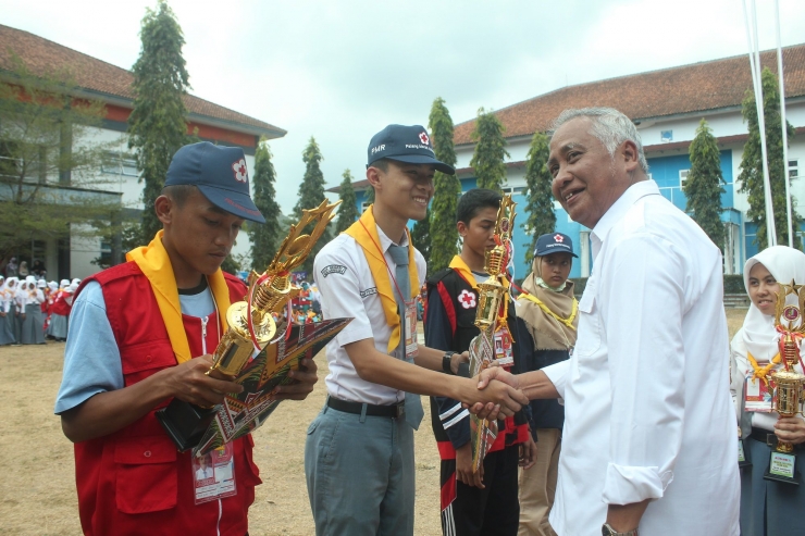 Drs. Setiawan, M. Hum serahkan Piala Penghargaan kepada peserta Jumbara PMR Wira usai upacara penutupan, Minggu (7/10)