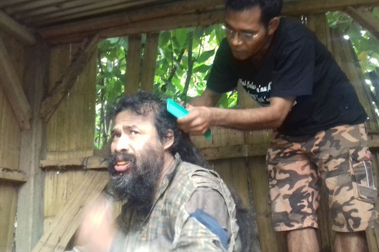 Pastor Aven saat memotong rambut Tarsisius yang menjadi salah satu penderita ODGJ di Manggarai Timur( foto Kompas.com)