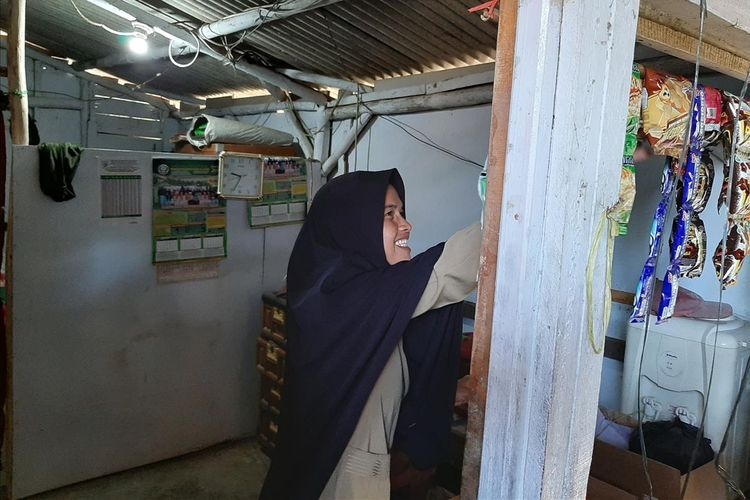 Nining Suryani (44) menunjukkan isi rumahnya yang menempati bagian toilet sekolah di SDN Karyabuana 3, Kecamatan Cigeulis, Kabupaten Pandeglang, Banten, Senin (15/7/2019)(KOMPAS.com/ ACEP NAZMUDIN)