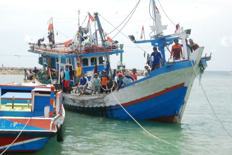 Nelayan bersiap dalam kapal yang sedang merapat di Pelabuhan Perikanan Sadeng, Gunung Kidul, Yogyakarta pada awal Desember 2015. Nelayan merupakan profesi yang riskan akan kecelakaan dan kematian, sehingga pemerintah berupaya memberikan asuransi nelayan. Foto: Jay Fajar/Mongabay
