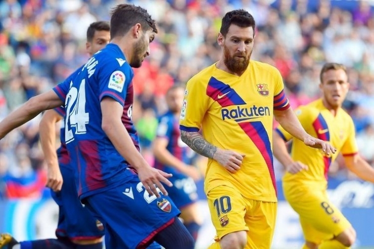 Lionel Messi membayang-bayangi Jose Campana pada pertandingan Levante vs Barcelona dalam lanjutan La Liga Spanyol di Ciutat de Valencia, 2 Oktober 2019. (sumber: AFP/JOSE JORDAN via kompas.com)