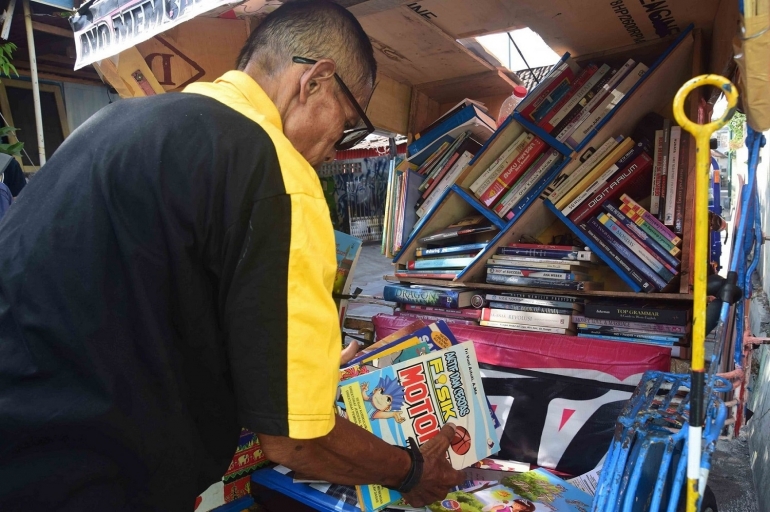 Pak Sutopo memperlihatkan koleksi buku di Becak Pustaka. (Dokumen Pribadi)