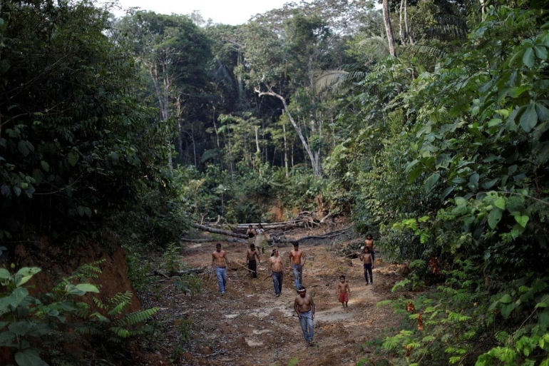 Suku Mura di pedalaman hutan Amazon berjalan di wilayah Negara bagian Amazonas, Brasil, yang terdampak pembalakan liar. (Reuters)