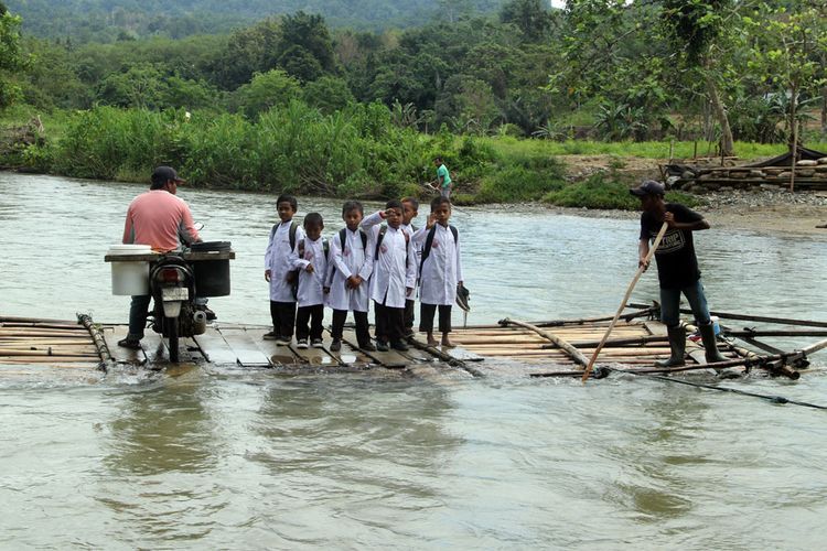 Anak sekolah menyeberang sungai (Kompas.com)