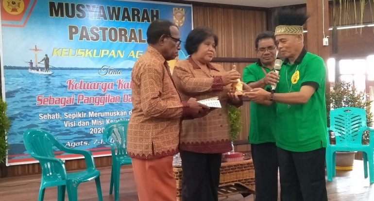 Mgr. Aloysius Murwito OFM menyerahkan cenderamata kepada pasangan keluarga yang memberi kesaksian pada pelaksanaan Musyawarah Pastoral ke-5 Keuskupan Agats, 7-13 Oktober 2019. Dokpri.