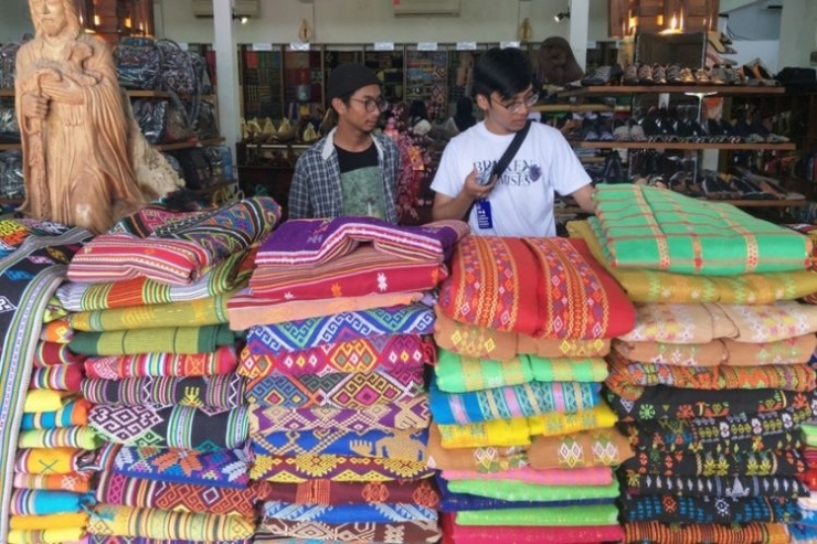 Pengunjung di antara tumpukan kain songke.(Kompas.com/SHERLY PUSPITA)