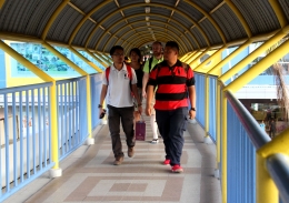 Sejumlah pengunjung dari Singapuran melintasi jembatan penghubung pelabuhan dan mall di Batam, belum lama ini. Foto/Joko Sulistyo