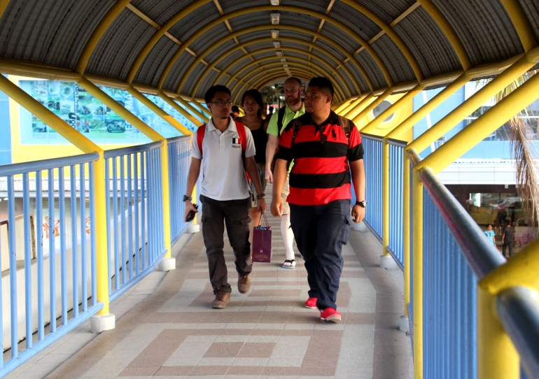 Sejumlah pengunjung dari Singapuran melintasi jembatan penghubung pelabuhan dan mall di Batam, belum lama ini. Foto/Joko Sulistyo