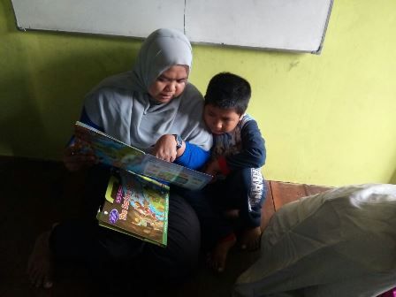 Relawan Kelas Kecil sedang membacakan cerita